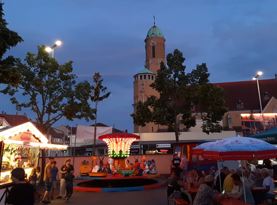 Die bunten Lichter der Karusselle und Verkaufsbuden sorgen in der Dämmerung für besonderes Flair.