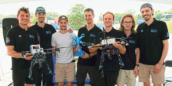 Strahlende Sieger: Das Drohnen-Team der Universität Klagenfurt mit Pokal und Hightech-Fluggeräten nach dem Triumph in den USA. Foto: University of Huntsville/Alabama