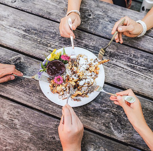 Bei einer zünftigen Hütten-Jause wird der süße Kaiserschmarrn gerne geteilt. Foto: SalzburgerLand Tourismus / Lisa Eiersebner
