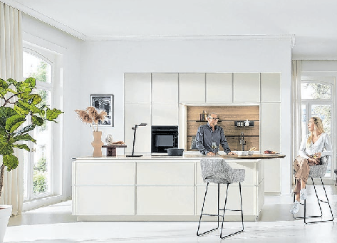 Modern und gemütlich wirkt diese grifflose Küchen- und Wohnlandschaft mit ihrem minimalistisch-klaren Design. Foto: AMK