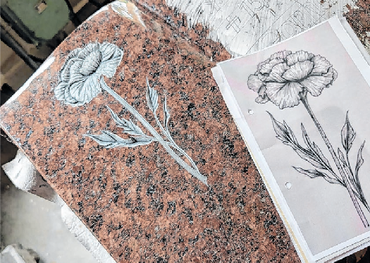 Fein gemeißeltes Blütenrelief auf rotem Granit: Steinmetzkunst bedeutet nicht nur Kraft, sondern auch Präzision, Geduld und filigrane Detailarbeit. Fotos: Marie Lindner