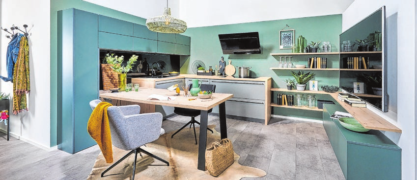 Moderne Wohnküche in trendigen Grünund Graufarbnuancen, kombiniert mit hellem Holz, was modern und wohnlich zugleich wirkt.