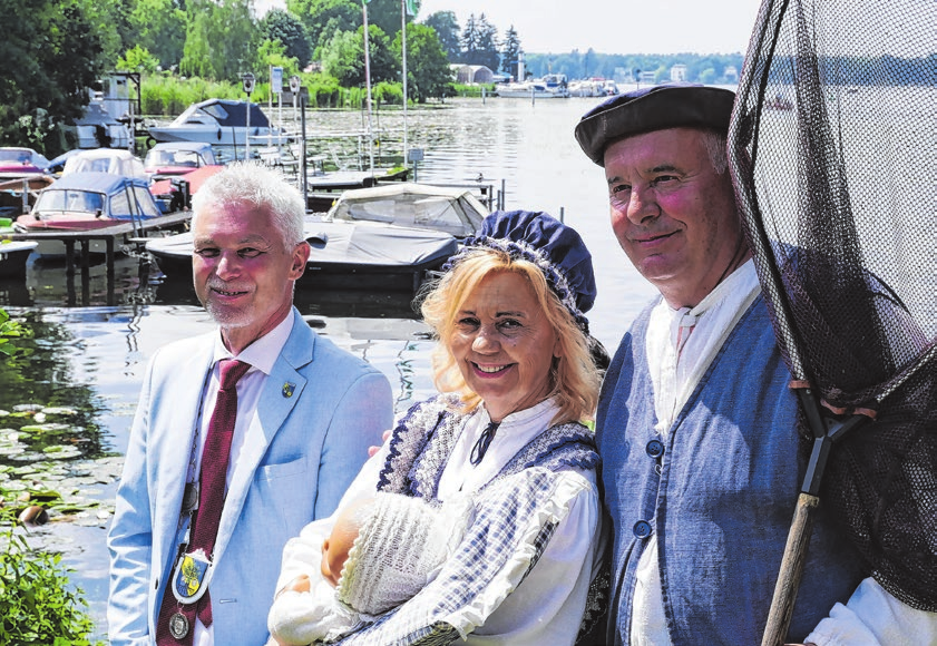 Es ist die Tradition in Erkner schlechthin und für viele Besuchende der eigentliche Festbeginn: Die Anlandung von Fischer Hans mit seiner Frau und Tochter. Fischer Hans kommt per Ruderboot auf dem Dämeritzsee und wird von Bürgermeister Henryk Pilz (links) und seinem „Gefolge“ herzlich begrüßt. Fotos (4): Daniela Sell/Stadt Erkner