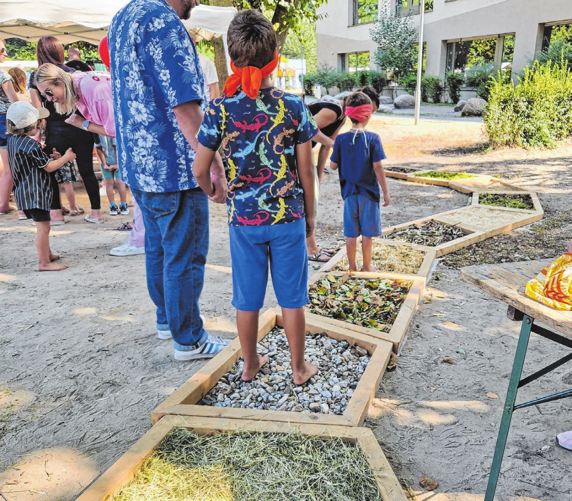 Den Barfußpfad mit verbundenen Augen entlang zu gehen, ist nochmal eine besondere Herausforderung - nicht nur für Kinder. Fotos: Tauscher/Kikuk