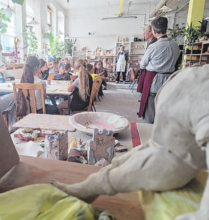 Eine Gruppe Kinder wird für den Töpferkurs eingewiesen.