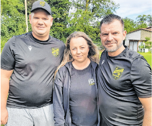 Die beiden E-Junioren-Trainer Mathias Taube (rechts) und Tino Schröpfer nehmen „Kathi“, wie sie im Verein genannt wird, in ihre Mitte. Foto: Tim Johnschker