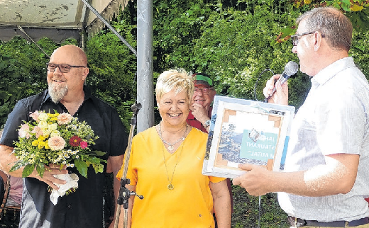 Bürgermeister Matthias Heim überreicht den beiden Gastronomen ein Geschenk zum Jubiläum.