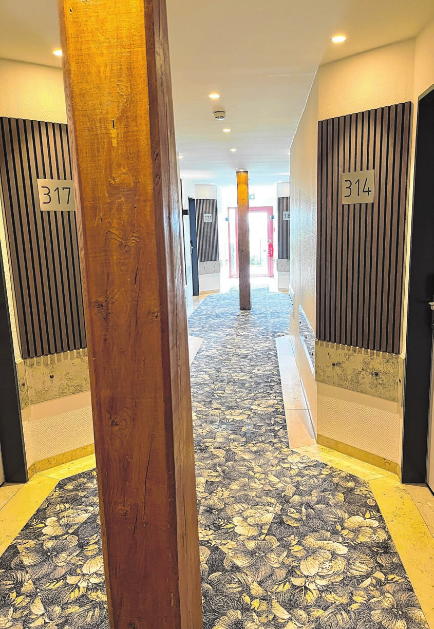 Im Hotel wurde auf ein einheitliches Erscheinungsbild viel Wert gelegt. Ob in den Gängen zu den Zimmern oder im Tagungsbereich - überall wiederholen sich Holzelemente wie die Säulen. Fotos: Adina Bauer