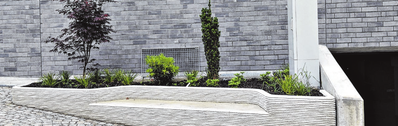 Die geschwungene Sitzbank aus Beton mit Pflanzbeet wurde im 3D-Drucker gedruckt.
