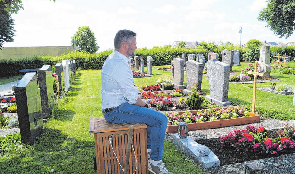 Ortsvorsteher Björn Schmid demonstriert auf dem Egginger Friedhof die praktische Ruhebank, auf der man am Grab innehalten kann.