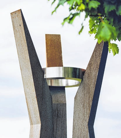 Skulptur: Drei geneigte Säulen aus Cortenstahl - stabil und zugleich beweglich - tragen einen gemeinsamen Ring. Die künstlerische Symbolik ist tief mit Römerstein verbunden.