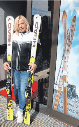 Claudia Beranek mit Ski, abgebildet daneben ein paar Ski, welche ihr Großvater und Geschäftsgründer Franz Beranek noch selbst hergestellt hat.