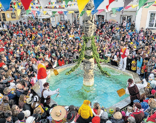 Ins kalte Wasser: Den Brauch des Brunnensprungs zur Fasnet gibt es inzwischen nur noch in Munderkingen. FOTOS: TROMMGESELLENZUNFT MUNDERKINGEN