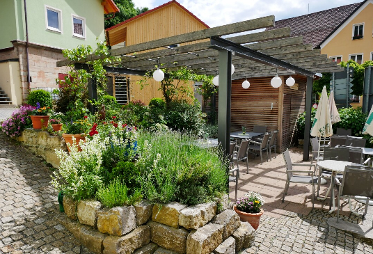 Genießen Sie ein kühles Bier mit einer Brotzeit oder ein Abendessen im Naturstein-Biergarten vom Hotel-Gasthof-Hereth in Wirsbergentweder auf einem der gemütlichen Sonnenplätze oder im Schatten der Kastanie! Der HotelGasthof Hereth liegt zentral in Wirsberg direkt am Main-Saale-Radweg, am Main-Radweg und am Euregrio-Egrensis-Radfernweg. Geöffnet ist täglich außer Mittwoch (Ruhetag) ab 15 Uhr und sonntags bereits ab Mittagstisch.