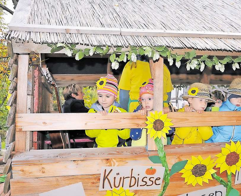 Mit Sonnenblumen dekoriert - beim Erntedankzug haben sogar die jüngsten Mützenicher ihren Spaß. Foto: Heiner Schepp