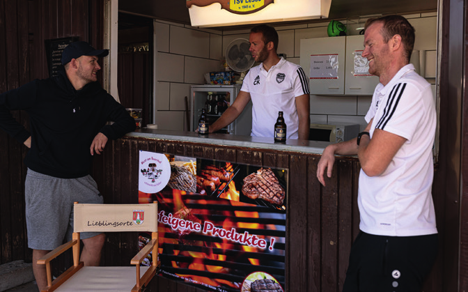 Cedric Klauenberg beim Plausch mit Freunden in der Bratwurstbude des TSV Lesse. © Rolf GroBjohann