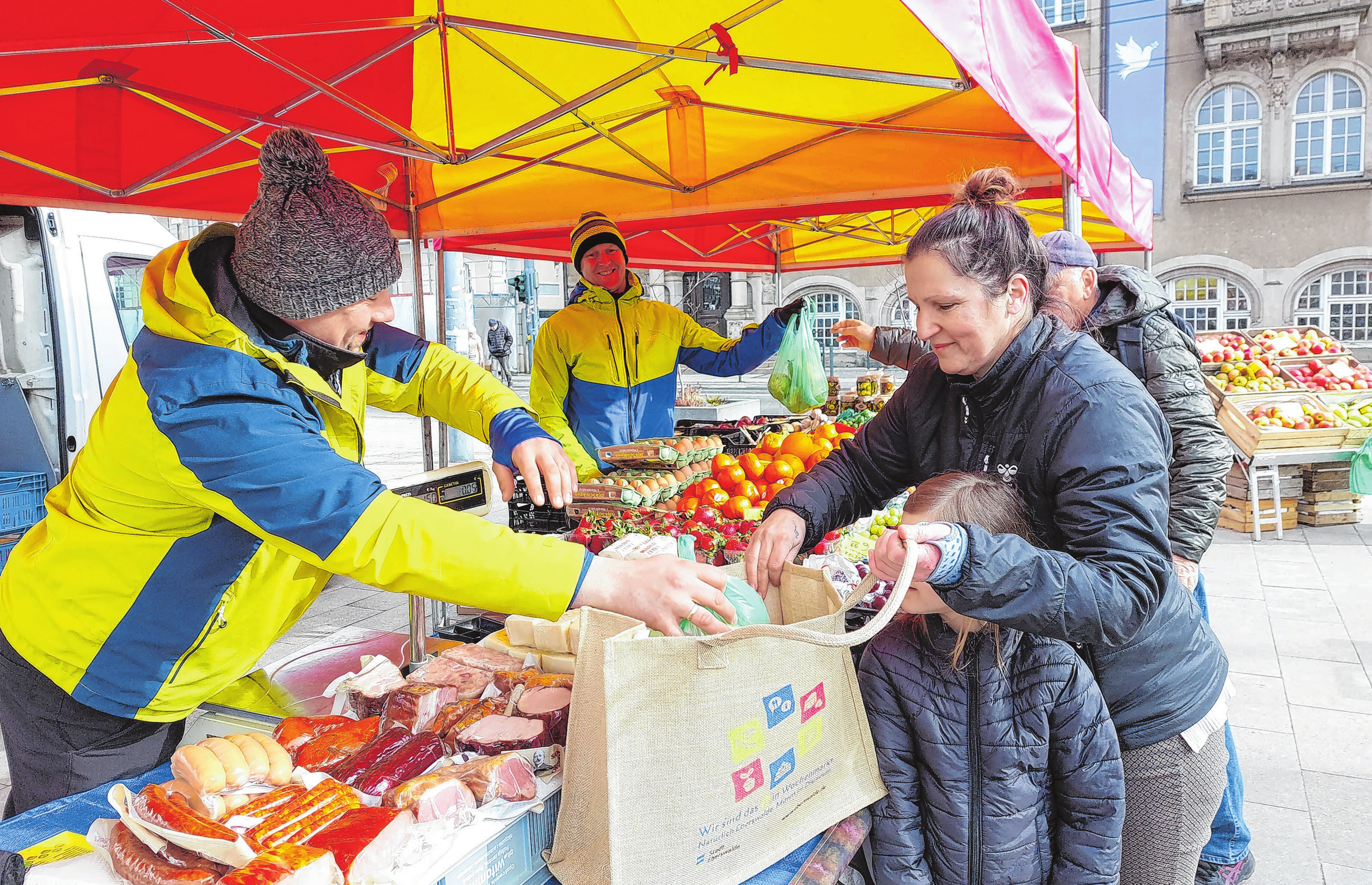 Nachhaltig einkaufen mit einer Jutetasche, die das Stadtmarketing für den Marktbesucher kreiert hat - hier Anja Brose (r.) am Obst- und Gemüsestand. Fotos (2): saschu