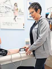 Christel Braun vom Sanitätshaus legt ein Blutdruckmeessgerät an. FOTO: MANFRED WELLER