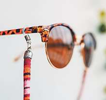 Das i-Tüpfelchen bei den Sonnenbrillen ist ein Brillenkettchen oder -band. Sie sind nicht nur stylish, sondern auch sehr praktisch. Foto: AnaVitoria - stock.adobe.com