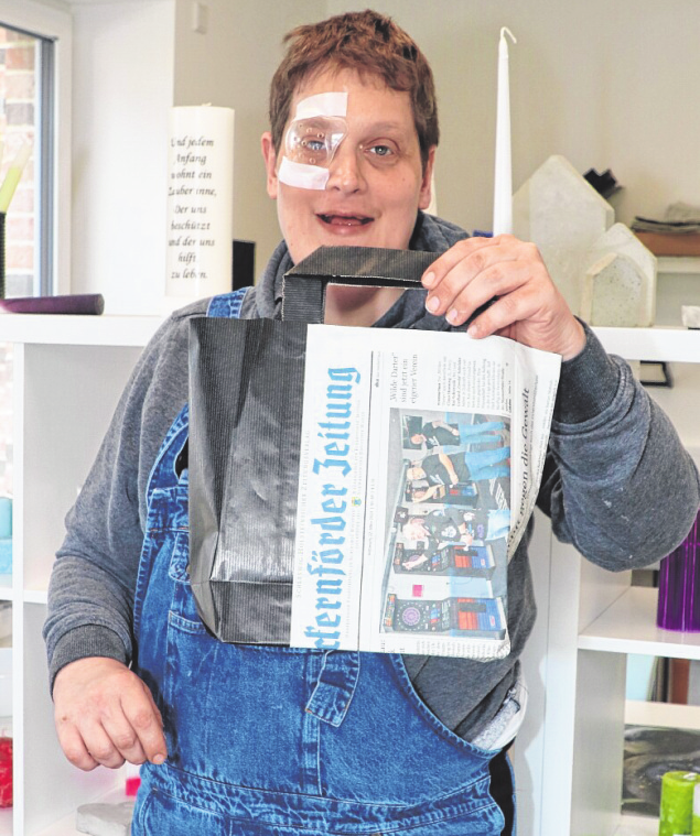 Christian Nadolski, einer der Beschäftigten in der Tagesförderstätte, mit einer Papiertüte, die aus einer abgelegten Zeitung gefertigt wurde.