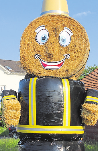 Als Feuerwehrmann macht eine überdimensional große Strohpuppe am Sterbfritzer Ortseingang auf das Fest aufmerksam.