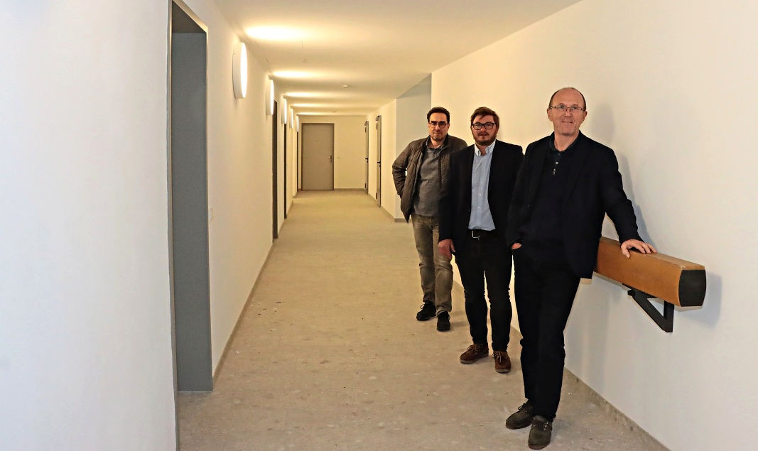 Am Schwebebalken von anno dazumal, Relikt aus der Nutzung der Immobilie als Turnhalle, lehnen (v.r.) Diözesanbaumeister Jochen Jarzombek, Martin Mäusbauer vom Katholischen Wohnbauwerk und Architekt Andreas Gremmelspacher.