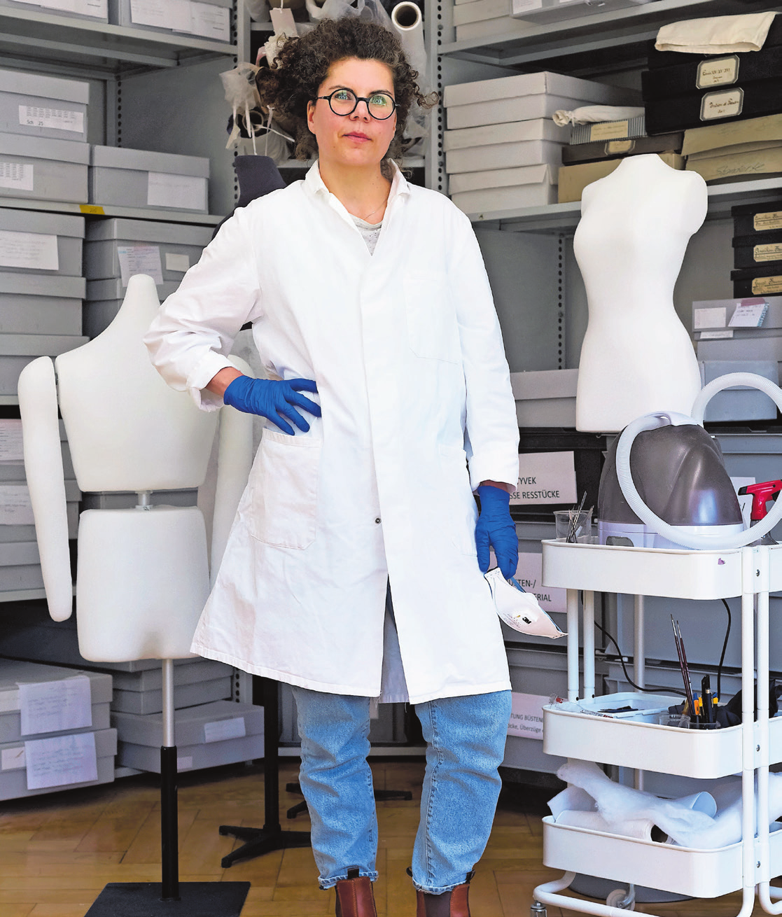 Claudia Merfert in ihrer Arbeitskleidung für spezielle Restaurierungen. Das Bild ist gleichzeitig Teil der Ausstellung «100 Shades of White» im Textilmuseum. Bild: Susanne Stauss