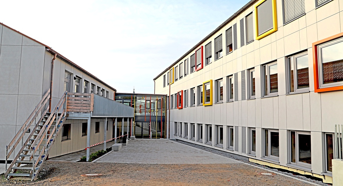 Farbenfroh und fröhlich sind die bunten Akzente, die bei der Sanierung der Grundschule Mietraching gesetzt wurden. Der Innenhof ist neu entstanden, der Pausenhof wartet noch auf den Abschluss der Sanierung.