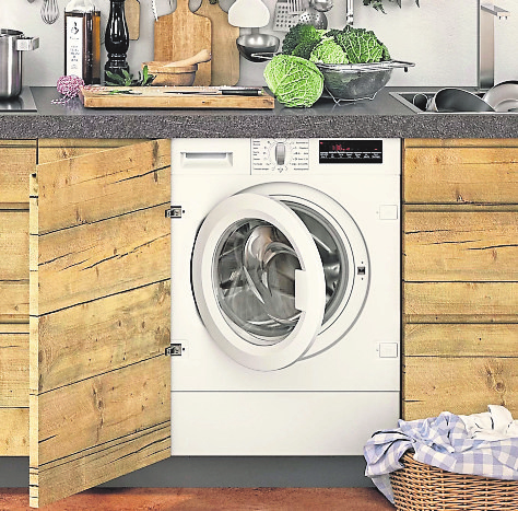 MULTIFUNKTIONAL Während der Essenszubereitung mal eben die Wäsche machen - beispielsweise mit diesem Waschtrockner hinter der Möbelfront. Foto: AMK