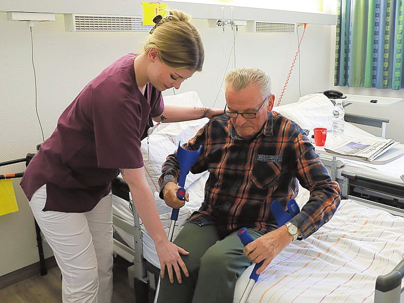 Unterstützung bei Alltagssituationen: Pflegefachkraft Linda Piontek hilft ihrem Patienten beim Aufstehen. FOTO CARITAS KLINIKEN
