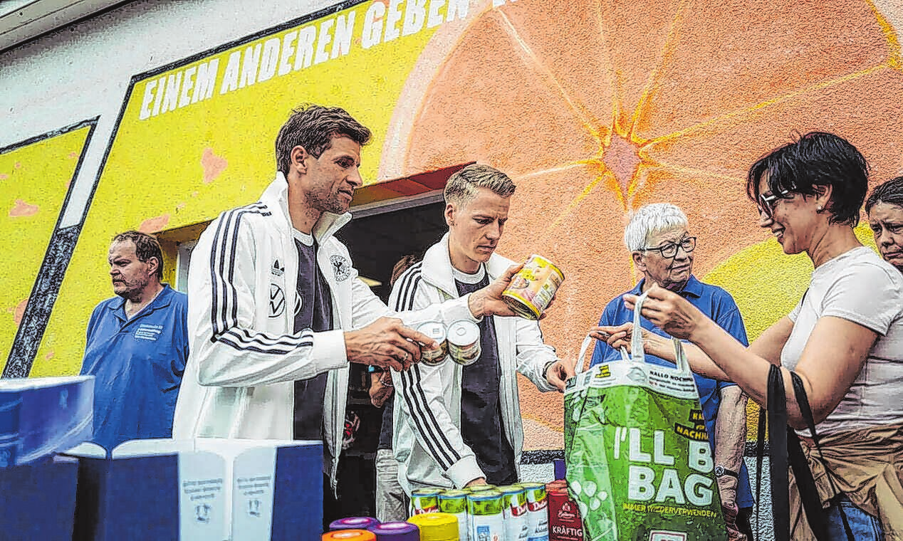 Geben Lebensmittel und Sachspenden aus (v.l.): Thomas Müller und Chris Führich. Foto: dfb/Philipp Reinhard