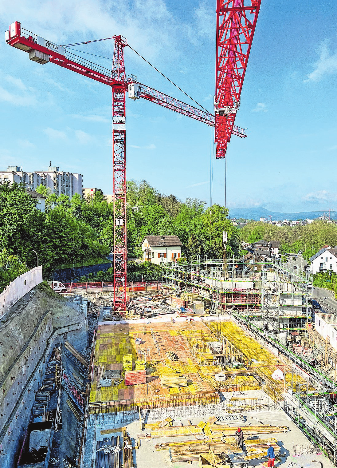 Blick auf die Deckenschalung über der Einstellhalle - im Hintergrund sind die Arbeiten im Erdgeschoss des Wohn- und Gewerbehauses im Gange.