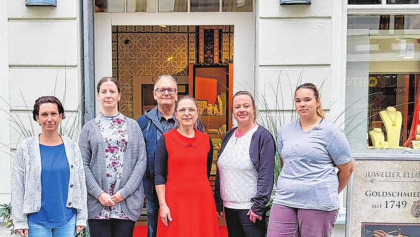 Anke und Andreas Elling (Bildmitte) mit ihrem Team vor dem Traditionsgeschäft im AltstadtCarrée Foto: privat