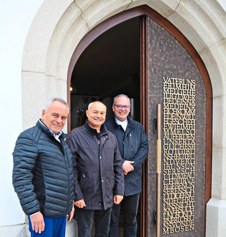 Voll des Lobes bewunderten (v.l.) Egings 1. Bürgermeister Walter Bauer, Kirchenpfleger Marian Musiol und Dekan Johannes Graf die künstlerisch einzigartige Bronzeverkleidung der rechten Flügeltür mit der Aufschrift „Vater unser“