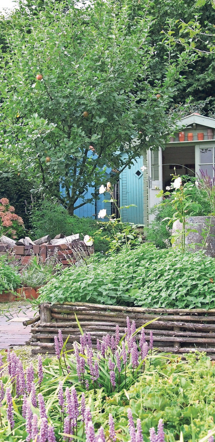 Ein geschwungener Weg lässt dieses schmale Grundstück größer wirken. Er führt an Stauden, einem Hochbeet und einer Feuerstelle vorbei und endet schließlich an einem skandinavisch anmutenden Gartenhaus. FOTO: APPELTERN