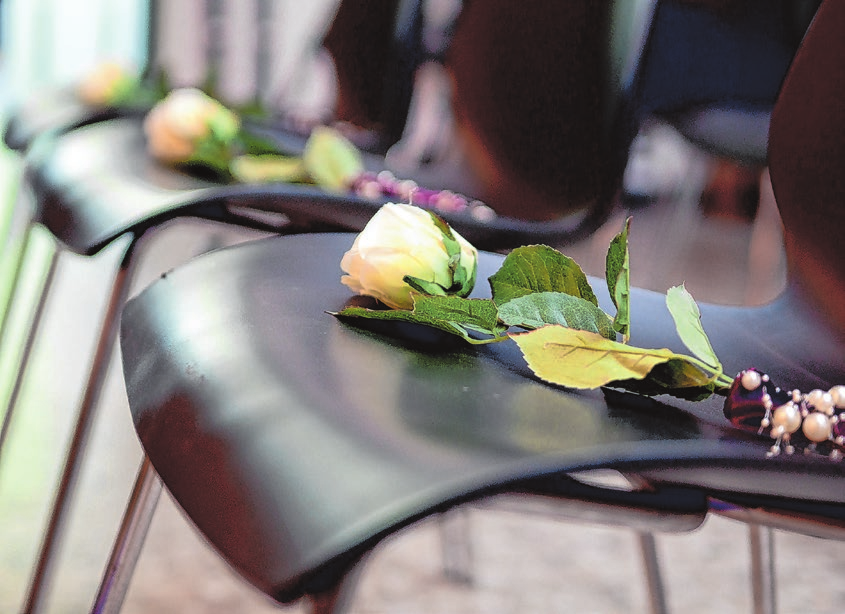 Ein besonderes Zeichen der Trauer sind Blumen - oft weiße Rosen, die bei der Feier auf die Stühle gelegt werden.