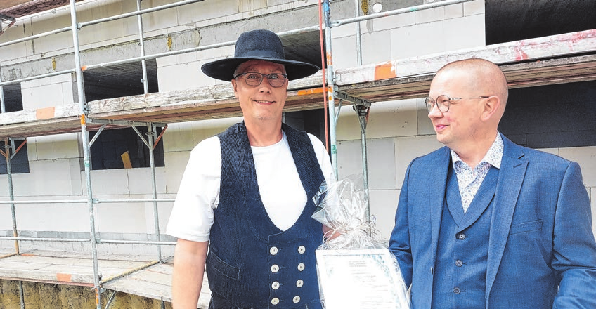 Mai 2023: Geschäftsführer Ramón Lutter warf gemeinsam mit Zimmermann Alexander Schmidt das Sektglas in den Bau. Die zukünftigen Mieter sollen hier glücklich leben, hieß es u. a. im Richtspruch. Foto: Archiv/saschu