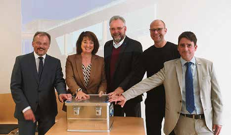 Bestückten die Zeitkapsel mit Briefen für die Nachwelt (v. I.): Ministerialbeauftragter Bernhard Buchhorn, Landrätin Maria Rita Zinnecker, Bürgermeister Lars Leveringhaus und Schuldirektor Stefan Zillenbiller. Foto: Landkreis Ostallgäu