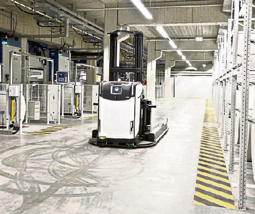 Vollautomatisch werden die die Rollen in die Druckmaschinen transportiert (links). Die fertigen Zeitung laufen aus der Druckmaschine aus und werden für den Versand vorbereitet. Fotos: Jens Weber