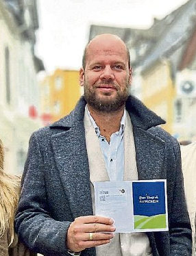 Daniel Lehmann, 1. Vorsitzender der Werbegemeinschaft, präsentiert den Rhein-Hunsrück Gutschein. Foto: Werbegemeinschaft Simmern