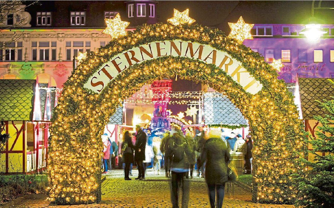 Der Görresplatz zeigt sich aus der Vogelperspektive als kleines weihnachtliches Dorf mit beleuchteten Hütten, farbig inszenierten Fassaden und dem Brunnen im Mittelpunkt. Foto: Koblenz-Touristik GmbH / Henry Tornow