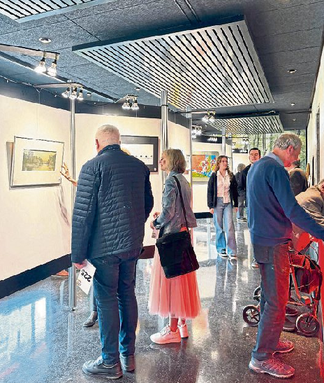 Besucher betrachten die ausgestellten Werke vor Beginn der Benefiz-Kunstauktion im Stöffelpark Enspel. Foto: Doris Kohlhas