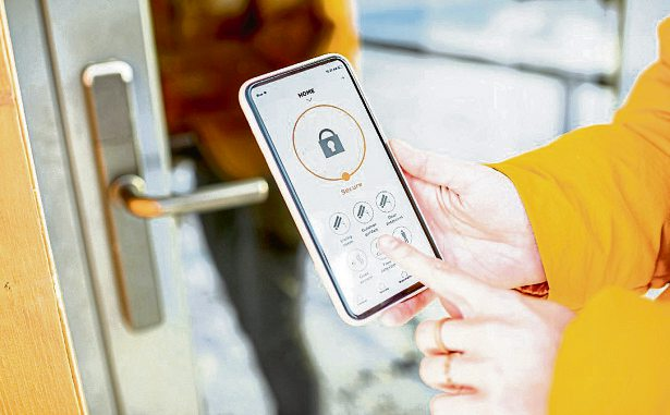 Verriegelung des Smartlocks an der Eingangstür aus der Ferne mit einem Smartphone. Ein Beispiel für die Verwendung intelligenter elektronischer Schlösser mit schlüssellosem Zugang. Foto: rh2010 stock.adobe.com