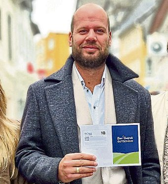 Daniel Lehmann, 1. Vorsitzender der Werbegemeinschaft, präsentiert den Rhein-Hunsrück Gutschein. Foto: Werbegemeinschaft Simmern