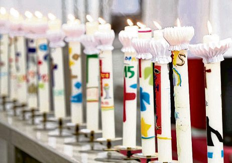 Leuchtende Symbole des Glaubens: Die bunten Kerzen der Kommunionkinder brennen während der Erstkommunionfeier und stehen für das Licht Christi und den Eintritt in die christliche Gemeinschaft. Foto: bilderstoeckchen-stock.adobe.com