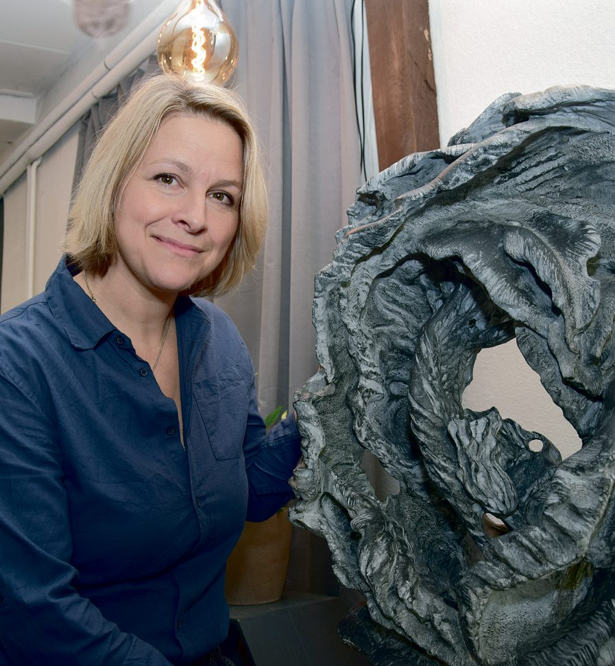 Im Bild präsentiert Anke Stein ihre Skulptur „Die Taucherin“ und erklärt: „Die Figur zeigt eine Taucherin in dynamischer Pose, die immer weiter hinab in den tosenden Sturm taucht, um sich mit Entschlossenheit dem inneren Chaos und der Unruhe zu stellen. Denn inmitten des Sturms findet sie eine ungeahnte Ruhe, aus der sich ihre innere Kraft entfaltet.“