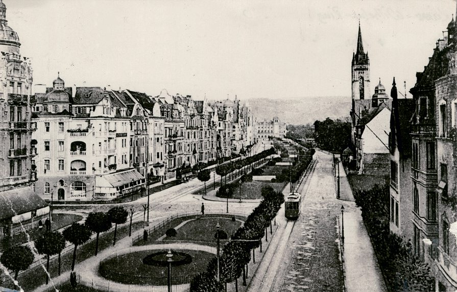 Der Koblenzer Kaiser-Wilhelm-Ring (heute Friedrich-Ebert-Ring) im Jahr 1910: auf der rechten Seite endet die Bebauung hinter der Christuskirche, die von 1901 bis 1904 errichtet wurde. Ab 1924 entstehen dort, wo auf dem Foto noch Bäume zu sehen sind, die beiden Gebäude der Handwerkskammer mit den Hausnummern 31 und 33. Quelle: Stadtarchiv Koblenz / StAK_FA_1_060