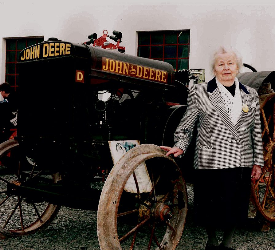 Maria Christian vor dem Oldtimer-Traktor eines Kunden bei der großen Feier zum 125-jährigen Bestehen des Familienbetriebs.