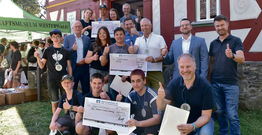 Die drei Siegerteams, vorne die Erstplatzierten aus der Freien Montessori-Schule Westerburg mit ihrem Paten Harald Orthey (MdB), dahinter die Zweitplatzierten der Realschule plus Salz (Pate Klaus Lütkefedder, Bürgermeister der VG Wallmerod) sowie hinten die Drittplatzierten von der Ernst-Barlach-Realschule plus Höhr-Grenzhausen (Pate Stephan Bach, Beigeordneter der VG Ransbach-Baumbach). Die Preisgelder in Höhe von 1.000 Euro stellte die Westerwald-Bank zur Verfügung.