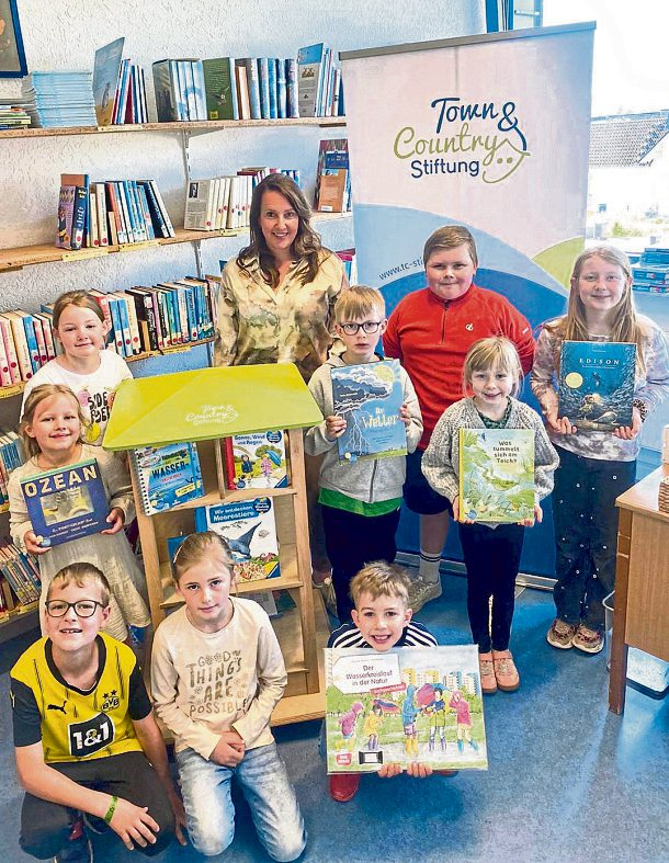 Kinder der Astrid-Lindgren-Grundschule in Herschbach werden durch die Town & Country Stiftung mit einem Bücherhaus inklusive Wasserbücher gefördert. Stiftungsbotschafterin Janina Corzilius übergab die Förderung bei einem Besuch in der Schulbücherei. Foto: Grundschule Herschbach